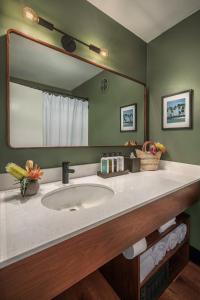 a bathroom with a sink and a large mirror at PACIFIC 19 Kona in Kailua-Kona
