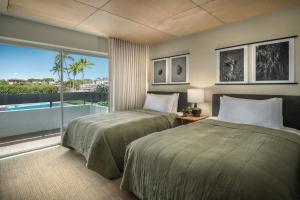 Habitación de hotel con 2 camas y balcón en PACIFIC 19 Kona en Kailua-Kona