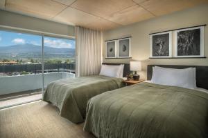 a hotel room with two beds and a large window at PACIFIC 19 Kona in Kailua-Kona +35 photos