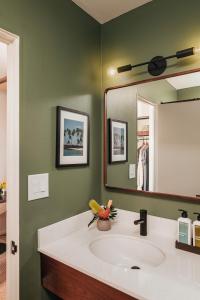 a bathroom with a sink and a large mirror at PACIFIC 19 Kona in Kailua-Kona