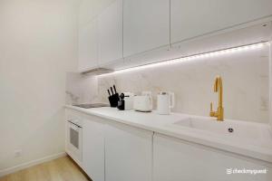 una cocina con armarios blancos y fregadero en Charming appart 8P - Etienne Marcel Marais, en París