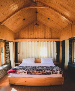 uma cama num quarto com tecto em madeira em Griffons Cafe and Stay em Dharamshala