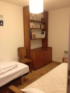 Habitación con 2 camas y estante para libros en Bulle de tendresse en Provence - Parking Piscine & Jaccuzzi - Peypin, en Peypin