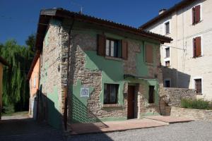 une vieille maison en pierre avec de la peinture verte sur le côté dans l'établissement La Ca' Tòrta - Rustico ristrutturato, à Neviano degli Arduini