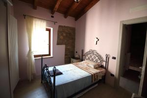 una camera con un letto in una stanza con una finestra di La Ca' Tòrta - Casa intera a Neviano degli Arduini