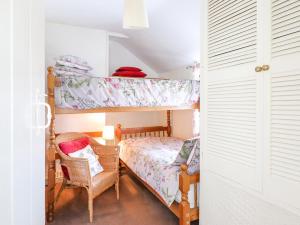 a bedroom with a bunk bed and a chair at The Old Post Office in Colwyn Bay