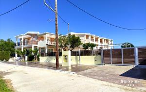 una casa bianca con una recinzione di fronte di Jenny Hotel a Laganas