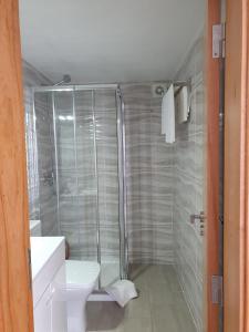 a bathroom with a shower and a white toilet at Casasoutelo 
