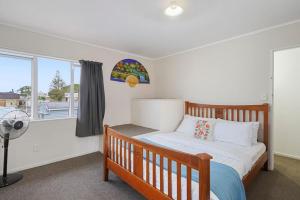 1 dormitorio con cama de madera y ventana en Comfy One Bed Delight - Parking - WIFI - Netflix, en Auckland