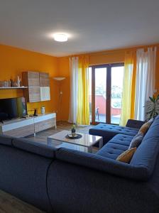 a living room with a blue couch and a table at Apartman Biba in Labin +25 photos