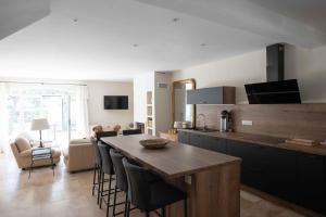 kuchnia ze stołem i krzesłami oraz salon w obiekcie Maison Cocoon Lourmarin 6 personnes w mieście Lourmarin