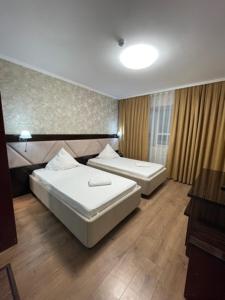 Habitación de hotel con 2 camas y escritorio en Diar, en Atyraū
