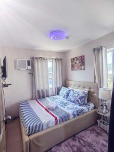 a small bedroom with a bed with blue and white sheets at Caren 8-Spatial Condo Maa 2br fully-furnished wtih unli Pool access in Ma-a