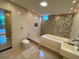 y baño con bañera, aseo y lavamanos. en Casa na Praia Norte da ilha, en Florianópolis