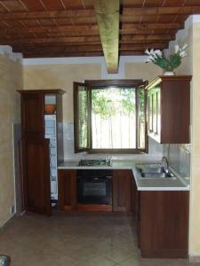a kitchen with a sink and a stove and a window at Il Punto Verde in SantʼAntonio