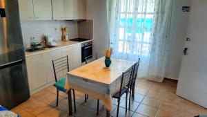 una cocina con una mesa con sillas y un jarrón. en Seaside Residence Kiki Prassa,Kimolos, en Kimolos