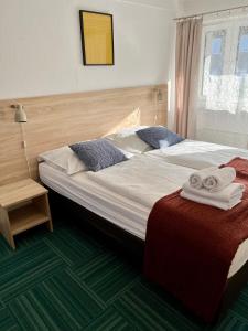 カルパチにあるAzalia Karpaczのベッドルーム1室(大型ベッド1台、タオル付)