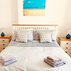 um quarto com uma cama com toalhas em 3 Bed House with Garden near Weymouth Beach em Weymouth