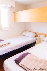 a room with two beds and a window at Camping Valencia el Saler in El Saler