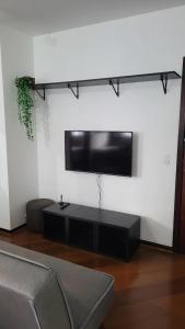 sala de estar con TV de pantalla plana en la pared en Confortável, Equipado e Bem Localizado c/ Garagem, en Curitiba