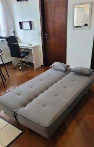 Cama grande en habitación con escritorio en Confortável, Equipado e Bem Localizado c/ Garagem, en Curitiba