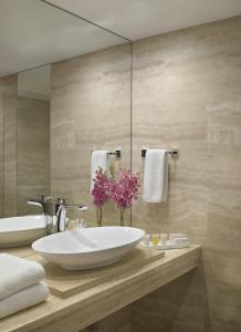 baño con lavabo blanco grande y espejo en Grand Beach Hotel Surfside West, en Miami Beach