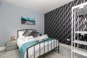 a bedroom with a bed and a black and white wall at 4 Bed 2 Bath Luxury Home in County Durham in Chilton