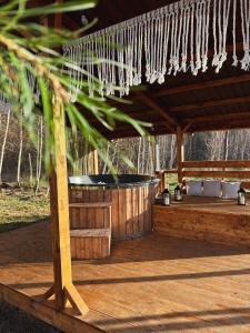 a wooden deck with a hot tub under a roof at Domek nad Zegrzem in Arciechow