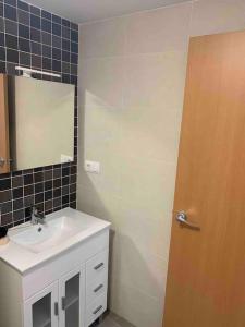 a bathroom with a sink and a mirror and a door at The Apartment Olivia in Moncófar