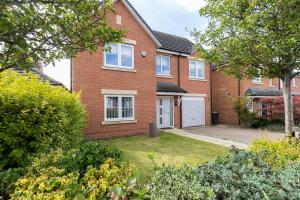 a brick house with a garage in a yard at 4 Bed 2 Bath Luxury Home in County Durham in Chilton