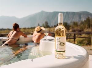 a bottle of wine sitting on top of a bath tub at Similkameen Wild Resort & Winery Retreat in Cawston