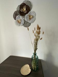 un vase avec des fleurs sur une table dans l'établissement Les cerisiers, 