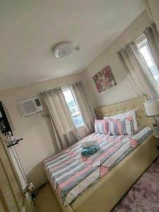 a bedroom with a large bed with pink and purple pillows at Caren 8-Spatial Condo Maa 2br fully-furnished wtih unli Pool access in Ma-a +23 photos