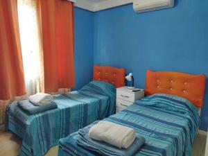 2 camas en una habitación con paredes azules en La casa ideal para el momento que buscabas., en Punta del Este