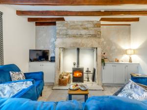 a living room with a blue couch and a fireplace at South View in Haydon Bridge