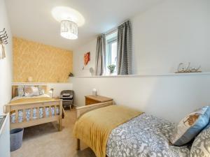 a bedroom with a bed and a chair and a window at South View in Haydon Bridge