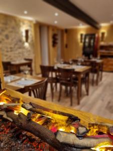 a fire in a room with tables and chairs at Hôtel Picheyre in Formiguères