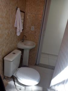 a bathroom with a white toilet and a sink at Pousada Monsenhor in Cachoeira Paulista