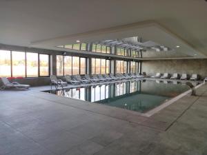 basen w budynku z krzesłami wokół niego w obiekcie Marina View 15 & SPA w Dziwnowie
