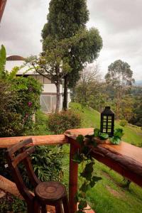 uma lanterna sentada numa cerca de madeira ao lado de um banco em Hotel Campestre La Posada Del Rancho em Popayán