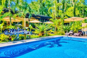 uma piscina com guarda-sóis e um resort em Exôtico Beach & Rooms em Puerto Viejo