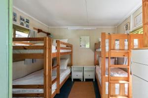 a room with three bunk beds and a refrigerator at Authentic Swedish family home on the archipelago in Stavsnäs