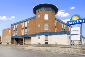 a brick building with a clock tower on top of it at Days Inn by Wyndham Estevan in Estevan