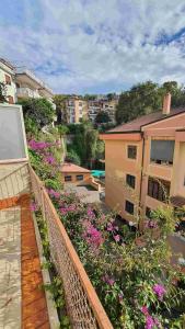 a balcony with pink flowers and a building at Bedrock in Salerno