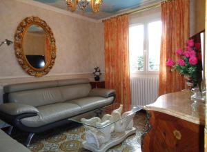 ein Wohnzimmer mit einem Sofa und einem Spiegel in der Unterkunft Gîte Au Clair Matin ,la Mure, les passerelles Monteynard in Pierre-Châtel