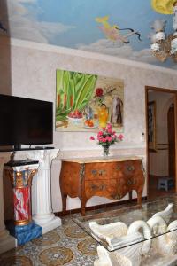 ein Wohnzimmer mit einem TV und einem Tisch mit Blumen in der Unterkunft Gîte Au Clair Matin ,la Mure, les passerelles Monteynard in Pierre-Châtel