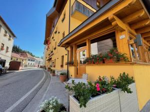 a building with flowers on the side of a street at Hotel Trieste in Tarvisio