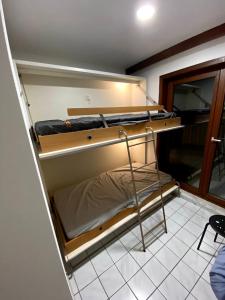 a room with two bunk beds and a chair at Appart sympa 6p avec garage et terrasse ensoleillée et spacieuse à 25m de la Mer Westende in Middelkerke