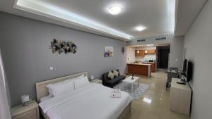 a bedroom with a large bed and a living room at Amazing Sea View Flat On The Beach in Ras al Khaimah