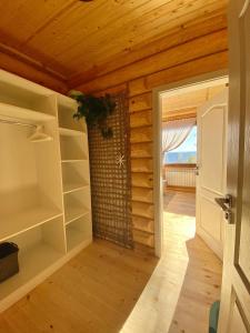 a room with wooden ceilings and shelves and a door at Вила Брезите in Pamporovo